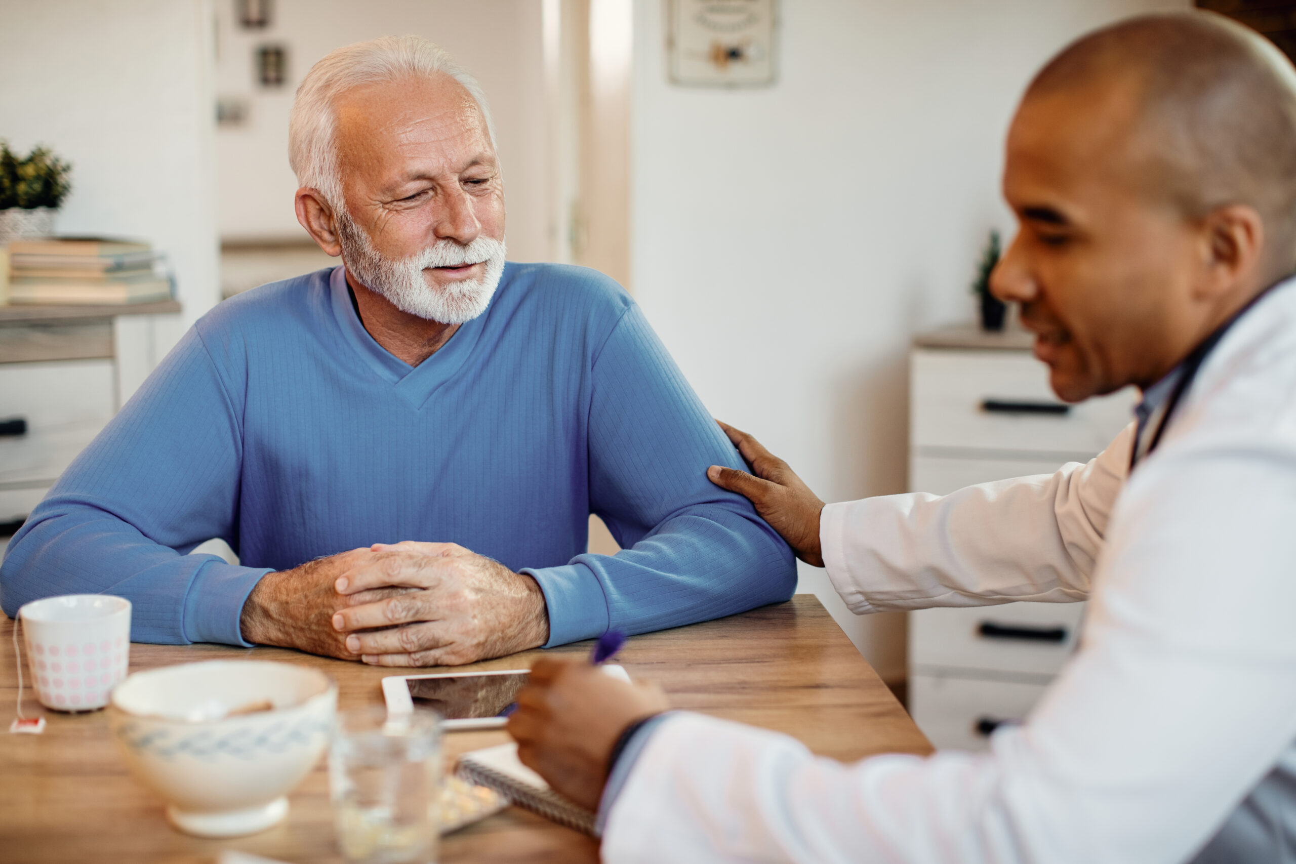 mature-man-talking-african-american-doctor-during-home-visit