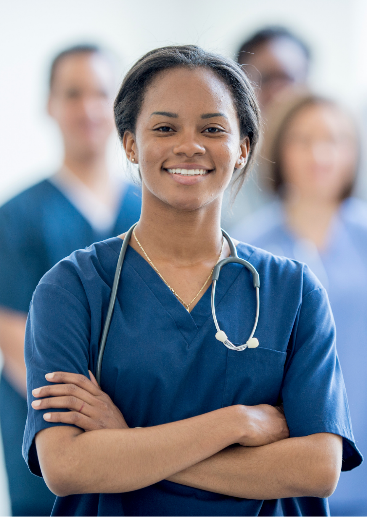 Clients 3 A nurse standing with her arms crossed and looking at the camera; medical professionals standing behind grouped together